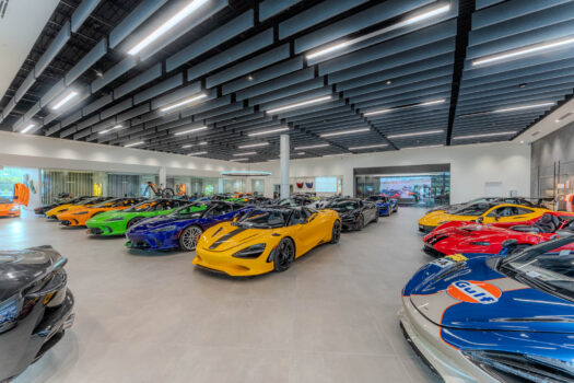 Interior view of the McLaren Winter Park luxury automotive showroom featuring high-performance supercars on the display floor.